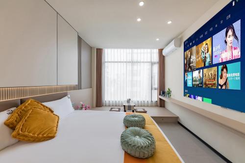 a hotel room with a large bed and a flat screen tv at 厦门初默民宿 in Xiamen