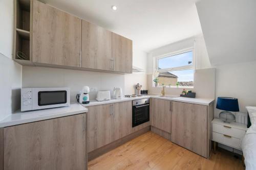 a kitchen with wooden cabinets and a microwave at Amazing Studio in Central London - 6 in London