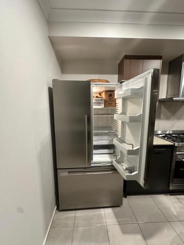 a refrigerator with its door open in a kitchen at Stylish four bedroom family retreat in Saltwater Coast in Point Cook