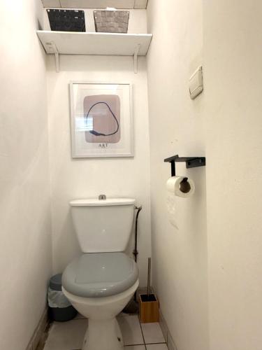 a bathroom with a toilet and a picture on the wall at Appartement lumineux Évreux centre in Évreux