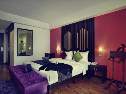 a hotel room with a bed with a laptop on it at Mercure Pontianak City Center in Pontianak
