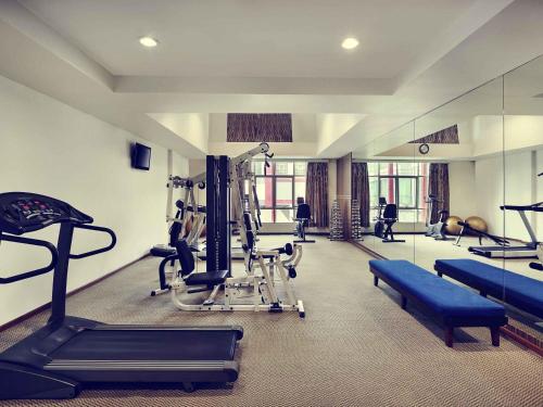 a gym with treadmills and machines in a room at Mercure Pontianak City Center in Pontianak