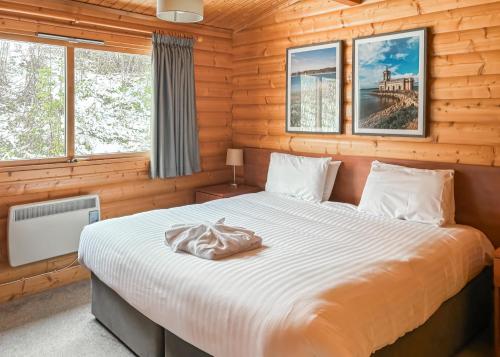 a bedroom with a bed in a log cabin at Rutland Lodges At Greetham Valley in Greetham