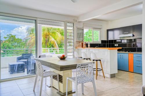 a kitchen with a table and chairs and a large window at Kay Ticole in Le Robert