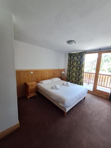 a bedroom with a bed and a large window at Chalet des Neiges : La Cime Des Arcs in Arc 2000