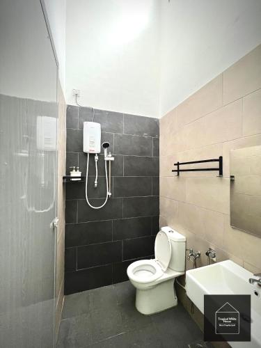 a bathroom with a shower and a toilet and a sink at Homestay Meru Ipoh Mus Lim Only Tropical White House in Ipoh