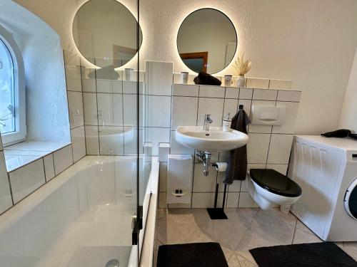 a bathroom with a tub and a sink and a toilet at Boutique Apartment im historischen Bahnhof - Potsdam & Berlin in Potsdam