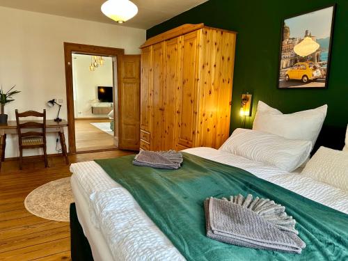 a bedroom with a large bed with a green blanket at Boutique Apartment im historischen Bahnhof - Potsdam & Berlin in Potsdam