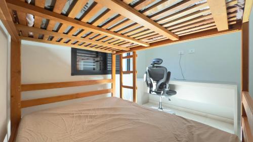 a bedroom with a bed and a chair in it at Casa Moderna para Familias com Piscina Churrasqueira Wi-Fi e Ar Condicionado in Peruíbe