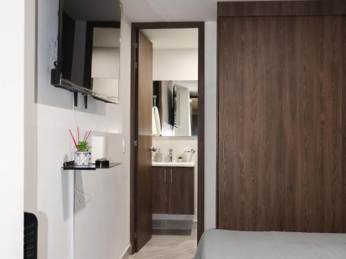 a bedroom with a wooden door and a television at Loft Moderno en Sabaneta Estilo Confort y Conexión in Sabaneta