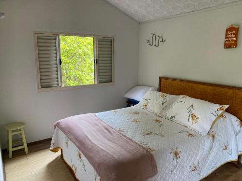 a bedroom with a large bed with a window at Fazenda Camping Cabral in São Lourenço
