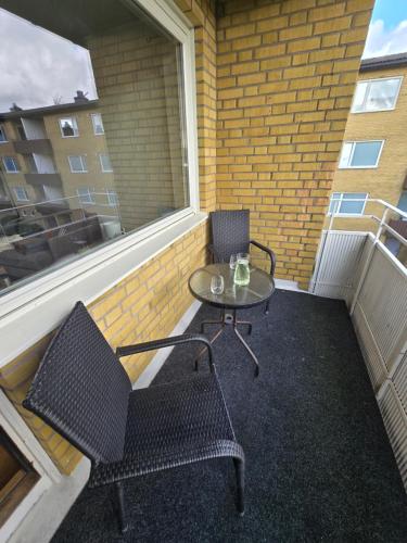 a table and chairs on a balcony with a window at Bright Family Apartment with Balcony in Gothenburg