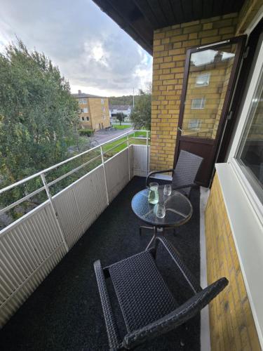 a patio with two chairs and a table on a balcony at Bright Family Apartment with Balcony in Gothenburg