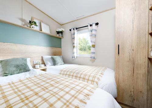 a bedroom with two beds and a window at Aber Bay Holiday Park in Aberystwyth