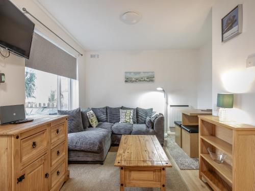 ein Wohnzimmer mit Sofa und Tisch in der Unterkunft Arthurs Den - Cottage in Brixham