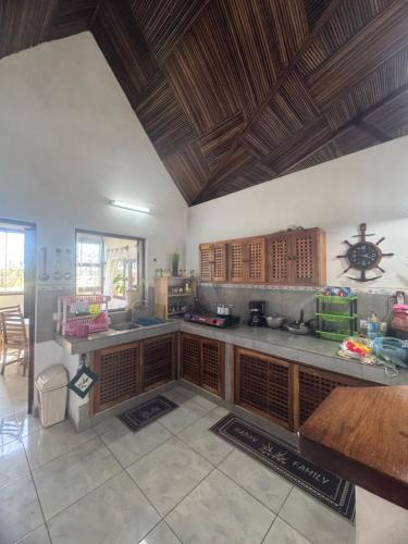 a large kitchen with wooden cabinets and a ceiling at Villa Nosy Be Madagascar in Dzamandzar