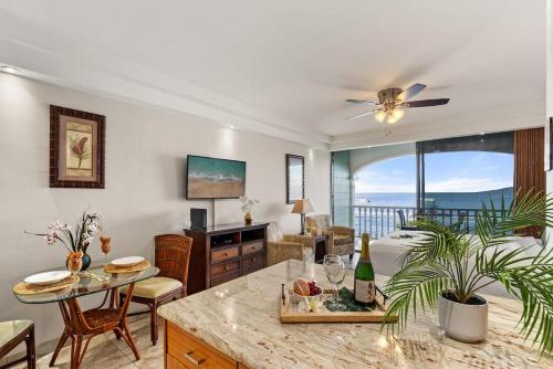 a living room with a table and a couch at Lahaina Shores 607 · LS 607 Beachfront Remodeled Studio Stunnin in Lahaina