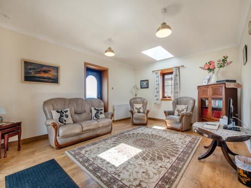 a living room with leather furniture and a table at Eryb Cottage - Uk46883 in Kilmory