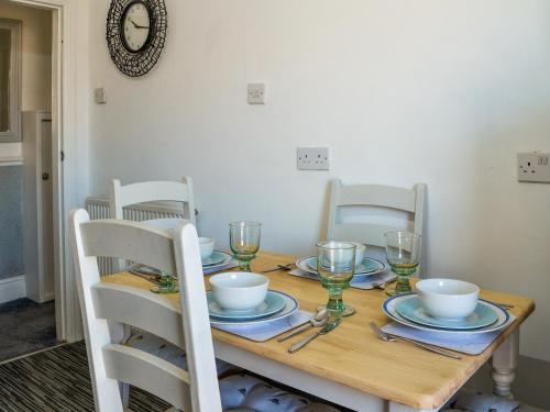 a dining room table with plates and glasses on it at The Apartment in Filey