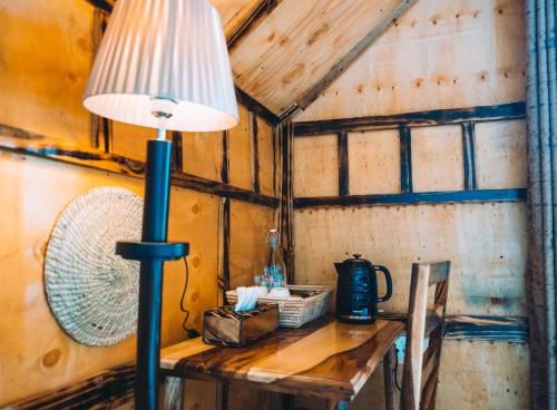 a lamp on a wooden table in a room at Samora River Lodge in Arusha