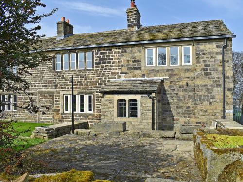 an old brick house with a lot of windows at Kirkstall Wood Farm in Ingrow