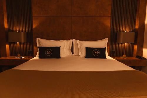a hotel room with a large bed with two pillows at Pousada Murano in Campos do Jordão