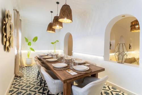 a dining room with a wooden table and white chairs at NJ House in Tangier