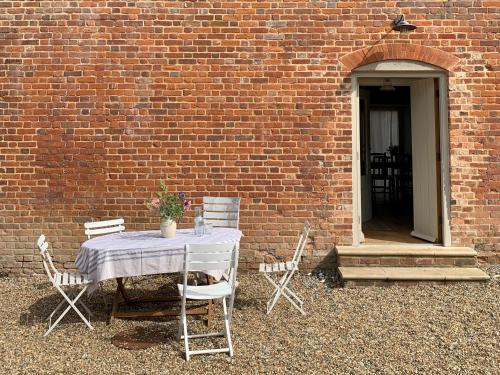 a table and chairs sitting next to a brick wall at The Stable in Womenswold