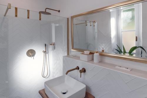a white bathroom with a sink and a mirror at Villa Elisabetta Lago Maggiore in Belgirate