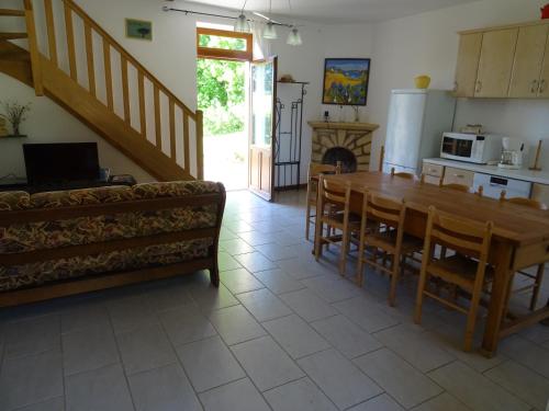 a kitchen and dining room with a table and a couch at Gite Périgourdin - 3 Chambres in Labrousse