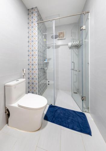 a bathroom with a white toilet and a blue rug at HIKARU Homestay in Dong Hoi
