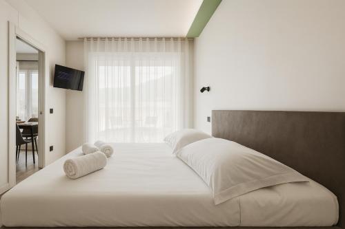 a bedroom with two beds with white sheets and a window at Jacuzzi Luxury Suite Iseo Elegant Apartment with Balcony Central Iseo in Iseo