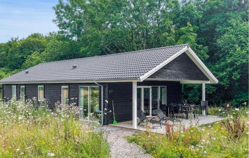 a black shed with a table and chairs in a field at 3 Bedroom Gorgeous Home In Tranekær in Tranekær