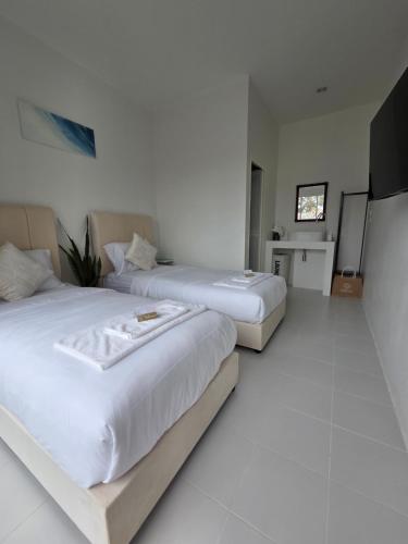 a hotel room with two beds and a flat screen tv at Treat Boutique HuaHin 94 in Hua Hin