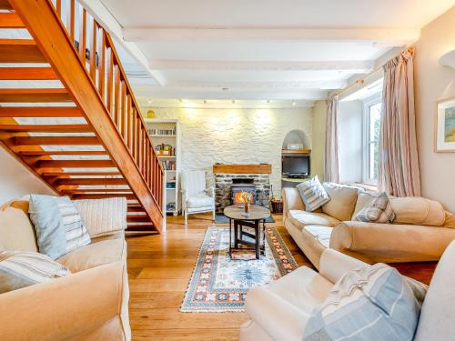 ein Wohnzimmer mit 2 Sofas und einer Treppe in der Unterkunft Trewellwell Cottage in Middle Mill