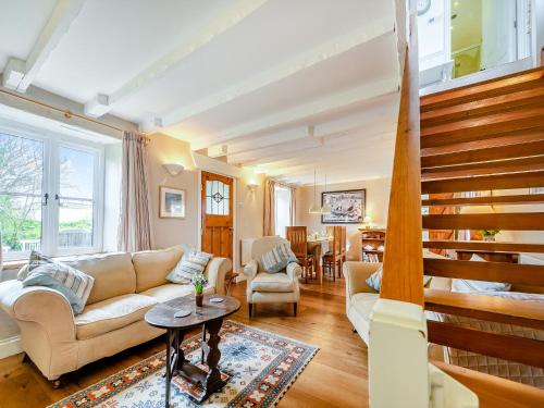 ein Wohnzimmer mit einer Couch und einer Treppe in der Unterkunft Trewellwell Cottage in Middle Mill