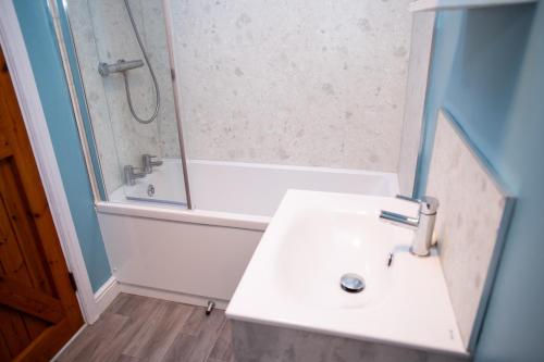 un bagno con lavandino, doccia e vasca di Pine Cottage Little Haven a Little Haven