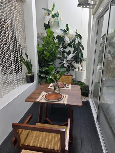 a table and chairs on a balcony with plants at Treat Boutique HuaHin 94 in Hua Hin