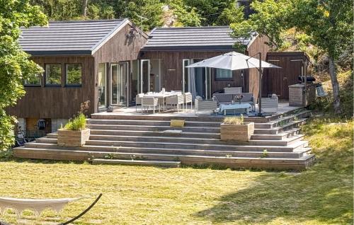 a house with a deck with a table and an umbrella at 2 Bedroom Beautiful Home In Gressvik in Slevik