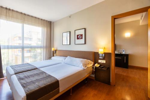 a bedroom with a large bed and a large window at Vértice Sevilla in Seville
