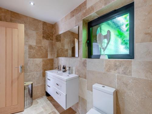 a bathroom with a sink and a window and a toilet at Foxton Lodge - Uk47296 in Harrietsham