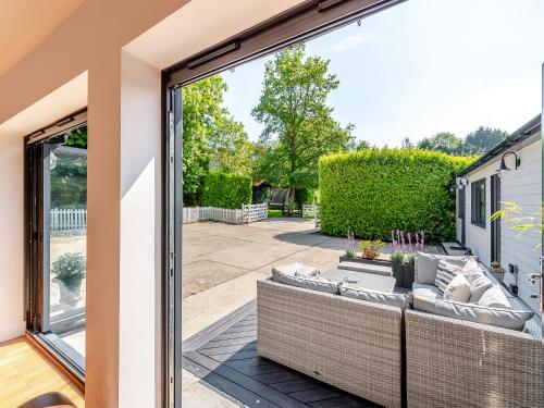 a patio with a couch outside of a sliding glass door at Foxton Lodge - Uk47296 in Harrietsham