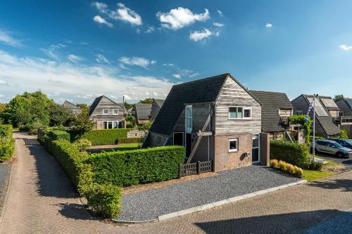 a house in a residential neighborhood with a driveway at Fries Vakantiehuis, grote tuin, nabij het Pikmeer in Grou