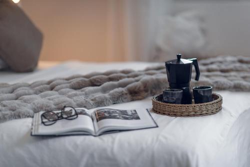 a book and glasses on a bed with a blanket at Villa Elisabetta Lago Maggiore in Belgirate
