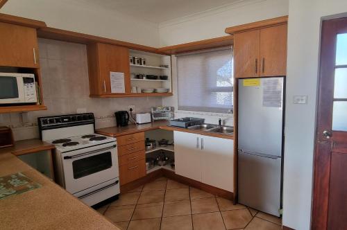 a kitchen with a white refrigerator and a stove at Kleinmond Panorama Holidays in Kleinmond