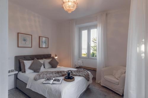 a bedroom with a large bed and a chair at Villa Elisabetta Lago Maggiore in Belgirate
