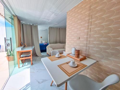 a living room with a white table and a chair at Casa Mar e Mar in Cabo Frio