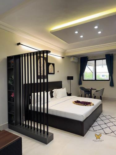 a bedroom with a bed and a desk in a room at Sweet Garden Hotel Kumasi in Trofwi