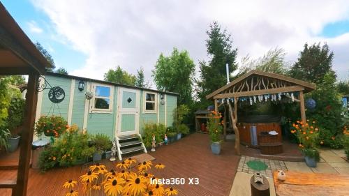 a house with a deck with flowers on it at Alice’s Garden @ Bleak House Farm in York