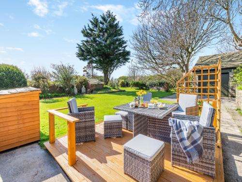 a patio with a table and chairs on a deck at Court End Cottage in Silecroft